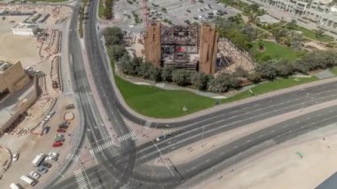 İş merkezinin arabalı otoparklarının gündüz vakti boş park yerlerini gösteren hava manzarası. İş sahasında kavşağa yakın yeni bir cami inşaatı