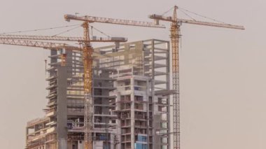 Konut kulelerinin hava zaman tüneli inşaatı. Açık gökyüzünün arka planına karşı pek çok gökdelen ve inşaat halindeki yeni binalar.