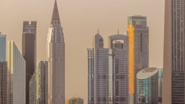 Şeyh Zayed Yolu çevresindeki yüksek binalar ve Dubai, BAE 'deki DIFC hava zaman çizelgesi. Günbatımında cam yüzeyi olan Uluslararası Finans Merkezi gökdelenleri