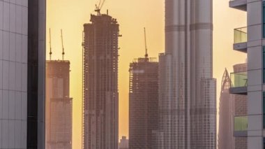 Dubai, Birleşik Arap Emirlikleri 'nde gün batımında restoranları olan alışveriş merkezinin dış tarafında. Arka planda yapım aşamasında olan en yüksek gökdelenlere sahip hava üst görünümü