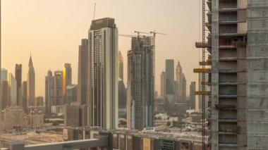 İnşaat alanı ve Sheikh Zayed Yolu çevresindeki yüksek binalar ve Dubai, BAE 'deki DIFC hava zaman çizelgesi. Günbatımında Uluslararası Finans Merkezi gökdelenleri