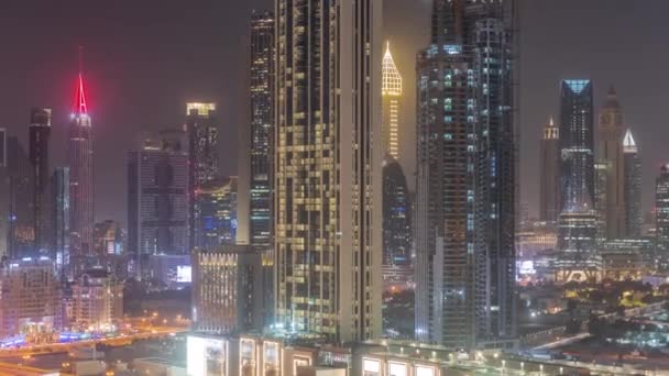 アラブ首長国連邦ドバイのシェイク ザイド ロードとDifc地区の空中夜のタイムラプスの周りの高層ビルの行 ガラス面を持つ国際金融センターの超高層ビル — ストック動画