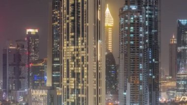 Dubai, BAE 'de tüm gece boyunca Sheikh Zayed Yolu ve DIFC bölge anteninin etrafındaki yüksek binaların sıraları. Uluslararası Finans Merkezi gökdelenleri ve ışıkları sönük