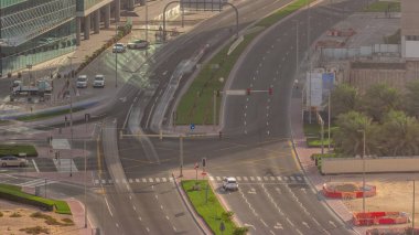 Dubai 'deki yol kesişiminde yoğun trafik var. Bölge hava trafiği, BAE. Akşamları palmiyeli yeşil çimenler. Birçok araba ve otobüs kavşakta ilerliyor, BAE