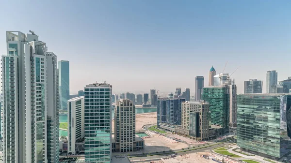 Business Bay Dubai skyscrapers with water canal aerial panoramic timelapse. Mixed use development with residential and office towers sharing the footprint equally