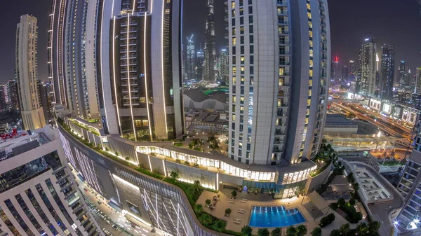 Tallest skyscrapers panorama in downtown dubai located on bouleward street near shopping mall aerial night timelapse. Walking area with rooftop gardens and swimming pool