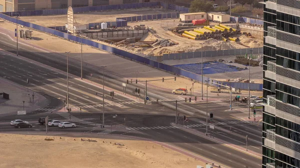 Dubai 'deki yol kesişiminde yoğun trafik var. Bölge hava trafiği, BAE. Birçok araba ve otobüs kavşakta ilerliyor, BAE. Arkasında inşaat alanı var