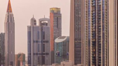 Sheikh Zayed Yolu ve DIFC bölgesi çevresindeki yüksek binalar ve Dubai, BAE 'deki gece gündüz geçiş zamanları. Cam yüzeyi olan Uluslararası Finans Merkezi gökdelenleri
