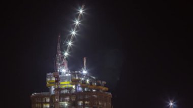 Konut kompleksli hava gece zaman çizelgesinin yapım süreci. Açık gökyüzünün arka planına karşı pek çok gökdelen ve inşaat halindeki yeni binalar.