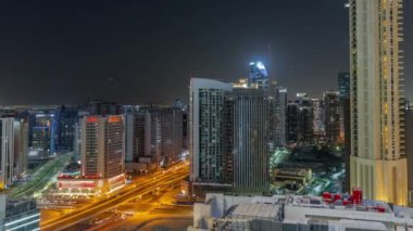 Dubai 'deki Business Bay' deki gökdelenler gece panoramik zaman çizelgesi. Turnalı yeni kulelerin kesişme ve inşaat sahası, Birleşik Arap Emirlikleri