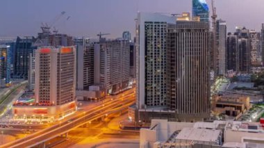 Dubai hava sahasındaki Business Bay 'deki gökdelenler panoramik zaman dilimine geçiş yapıyorlar. Gün batımından sonra vinçleri olan yeni kulelerin kavşağı ve inşaat sahası, Birleşik Arap Emirlikleri