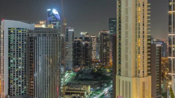 ドバイのビジネスベイでのスカイスクレーパー航空夜間のタイムラプス クレーン アラブ首長国連邦と新しい塔の近代的な建物や建設現場 — ストック動画