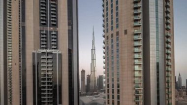 Dubai şehir merkezindeki en uzun gökdelenler, alışveriş merkezinin hava sahasının yakınındaki bulvar caddesinde gece gündüz geçiş zamanları. Güneş, güneş doğarken cam yüzeyden yansıyor