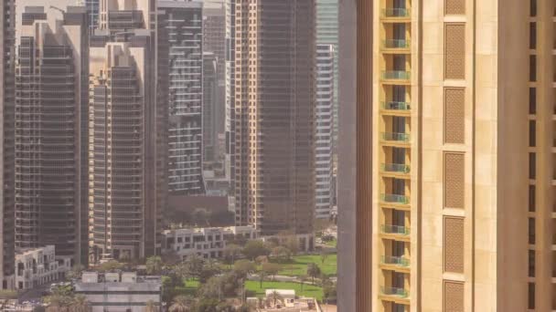 迪拜商业湾的摩天大楼整天在空中飞驰 阴影快速掠过 阿拉伯联合酋长国 院子里有棕榈树的绿色草坪 — 图库视频影像