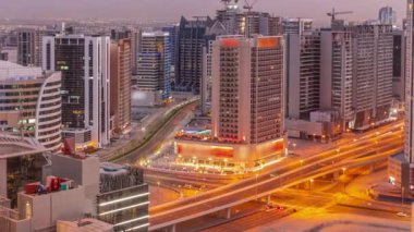 Dubai hava sahasındaki Business Bay 'deki gökdelenlerden gece geçiş zamanına kadar. Gün batımından sonra vinçleri olan yeni kulelerin kavşağı ve inşaat sahası, Birleşik Arap Emirlikleri