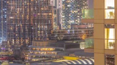 Dünya saatinde Dubai 'de, Birleşik Arap Emirlikleri' nde gece balkonlarında restoranlarla alışveriş merkezleri açılır. Arka planında en yüksek gökdelen olan gökyüzü manzarası. Işıklar yanıyor.