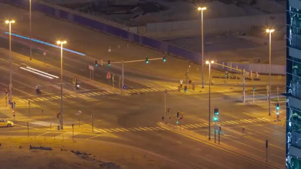 ドバイビジネスベイ地区の道路交差点でのブッシートラフィック航空夜間のタイムラプス Uae 建設現場は後ろです 多くの車やバスが交差点 Uaeに移動 — ストック動画