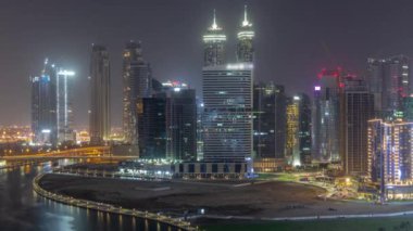 Dubai İş Koyu 'ndaki gökdelenlerin şehir manzarası. Bütün gece su kanalı havası var. Aydınlatılmış kuleleri ve rıhtımı olan modern gökyüzü. Uluslararası bir iş merkezi.