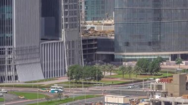 Ofis gökdelenleri ve kavşakta trafiği olan Dubai iş hangarı bölgesi. Avuç içi ve araba dolu yeşil çimenler kavşakta ilerliyor, BAE