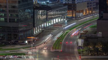 Dubai iş sahasındaki kavşakta yoğun trafik var. Hava sahasında gece uçuşu, BAE. Birçok araba ve otobüs iş yeri yakınlarındaki kavşakta ilerliyor, BAE