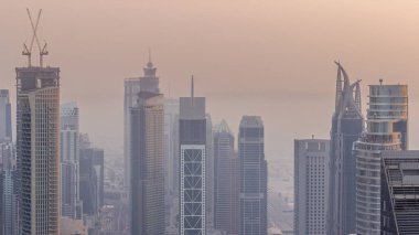 Şehir merkezinin ufuk çizgisi, modern mimari biçimli, zaman çizgisinin üstünde. Dubai iş hangarı kulelerinin hava görüntüsü. Akşamları sisli hava