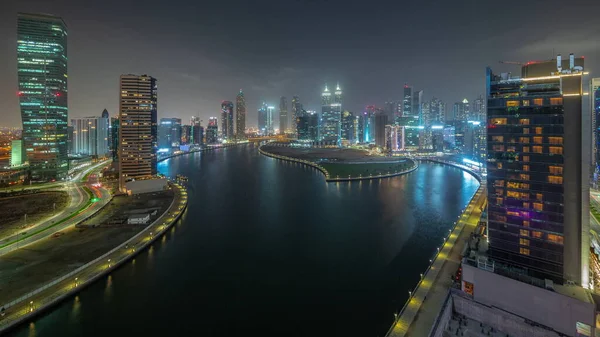 迪拜商业湾的城市景观与水渠和摩天大楼的空中夜间穿行 现代天际线与照明塔和海滨 国际商务中心 — 图库照片