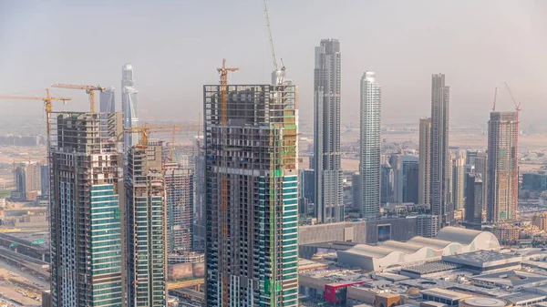 Dubai downtown with large-scale construction of a residential complex with a view of construction cranes aerial timelapse. Skyscrapers and shopping mall rooftop