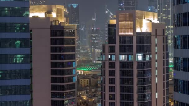 ドバイビジネスベイの高層ビルや金融街の空中夜間のタイムラプス ダウンタウンのライトアップされた塔と輝く窓があるスカイライン — ストック動画