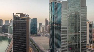 Dubai Business Bay 'deki ve şehir merkezindeki gökdelenlerin şehir manzarası. Günbegün su kanalından geceye geçiş zamanı. Günbatımından sonra kuleleri ve rıhtımı olan modern gökyüzü. Uluslararası bir merkez.