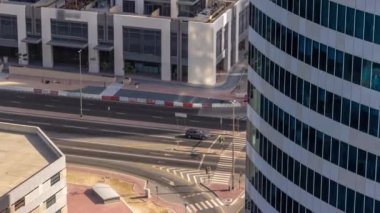 Ofis gökdelenleri ve kavşakta trafiği olan Dubai iş hangarı bölgesi. Dörtyol ağzında ilerleyen cam kulelerin ve arabaların arkasına bak, BAE