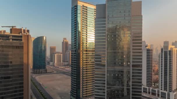 随着水渠空中时间的流逝 迪拜商业湾的玻璃摩天大楼的城市景观与日出时的阳光反射 现代天际线与塔和海滨 Center International — 图库视频影像