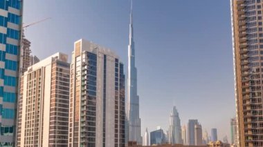 Şehir merkezindeki Dubai 'ye havadan panoramik manzara ve gün batımında Difc gökdelenleri ve Business Bay zaman dilimindeki kavşakta yoğun trafik. Güneş, kulelerdeki cam yüzeyden yansıyor