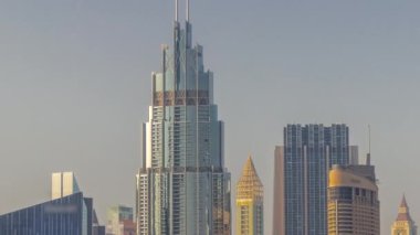 Şehir merkezindeki yüksek binalar ve Dubai, BAE 'deki finans bölgesi zaman çizelgesi. Gün batımında gökdelenlerin cam yüzeyinden yansımalar