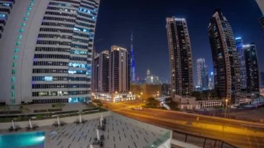 Dubai şehir merkezindeki hava manzarası ve Business Bay bölgesindeki kavşakta yoğun trafiği olan difc gökdelenleri. Aydınlatılmış yüzme havuzunun yanındaki sandalyeler
