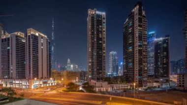 Şehir merkezindeki Dubai 'ye hava panoramik görüntüsü ve Business Bay' deki kavşakta yoğun trafiği olan difc gökdelenleri. Aydınlatılmış pencereli kuleler