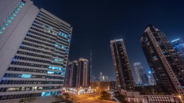 Şehir merkezindeki Dubai 'ye bakan hava panoramik manzarası ve yoğun trafik yoğunluğu olan difc gökdelenler Business Bay' de gece zaman çizelgesi üzerinde..