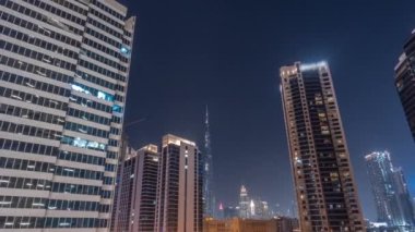 Şehir merkezindeki Dubai 'ye bakan hava panoramik manzarası ve tüm gece boyunca Business Bay bölgesindeki kavşakta yoğun trafik olan difc gökdelenleri..