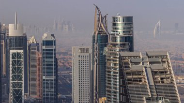Şehir merkezinin ufuk çizgisi, modern mimari biçimli, zaman çizgisinin üstünde. Dubai iş hangarı kulelerinin hava görüntüsü. Arka planda Dubai marina gökdelenleri
