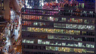 Ofis gökdelenleri. Finans bölgesi havacılık gece zaman çizelgesini aydınlatıyor. Yukarıdaki bir yolda parlayan pencerelere ve trafiğe en üst görünüm