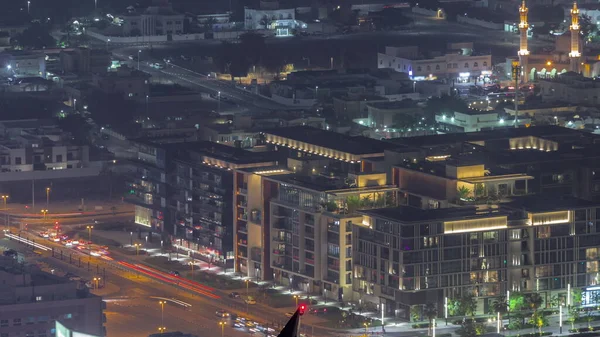 City Walk district aerial night timelapse, new urban area in Dubai downtown. Residential buildings and shopping zone with traffic on the road