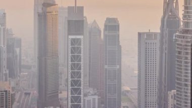 Şehir merkezinin ufuk çizgisi, modern mimari biçimli, zaman çizgisinin üstünde. Dubai iş hangarı kulelerinin hava görüntüsü. Akşamları sisli hava