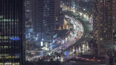 Dubai şehir merkezindeki kavşakta yoğun bir trafik var. Aydınlatılmış gökdelenler arasında bir çok araba kavşakta ilerliyor, BAE