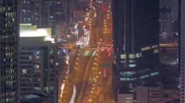 Şehir merkezindeki Dubai otobanında yoğun trafik var. Birçok araba kuleler ve gökdelenler arasında yol ayrımında ilerliyor, BAE