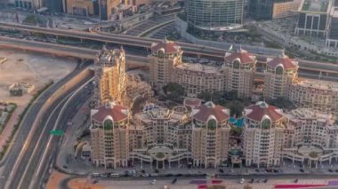 Dubai şehir merkezindeki üst geçit kavşağında yoğun trafik var. Gün batımında alışveriş merkezi ve otellerin yakınlarındaki kavşakta birçok araba hareket ediyor.