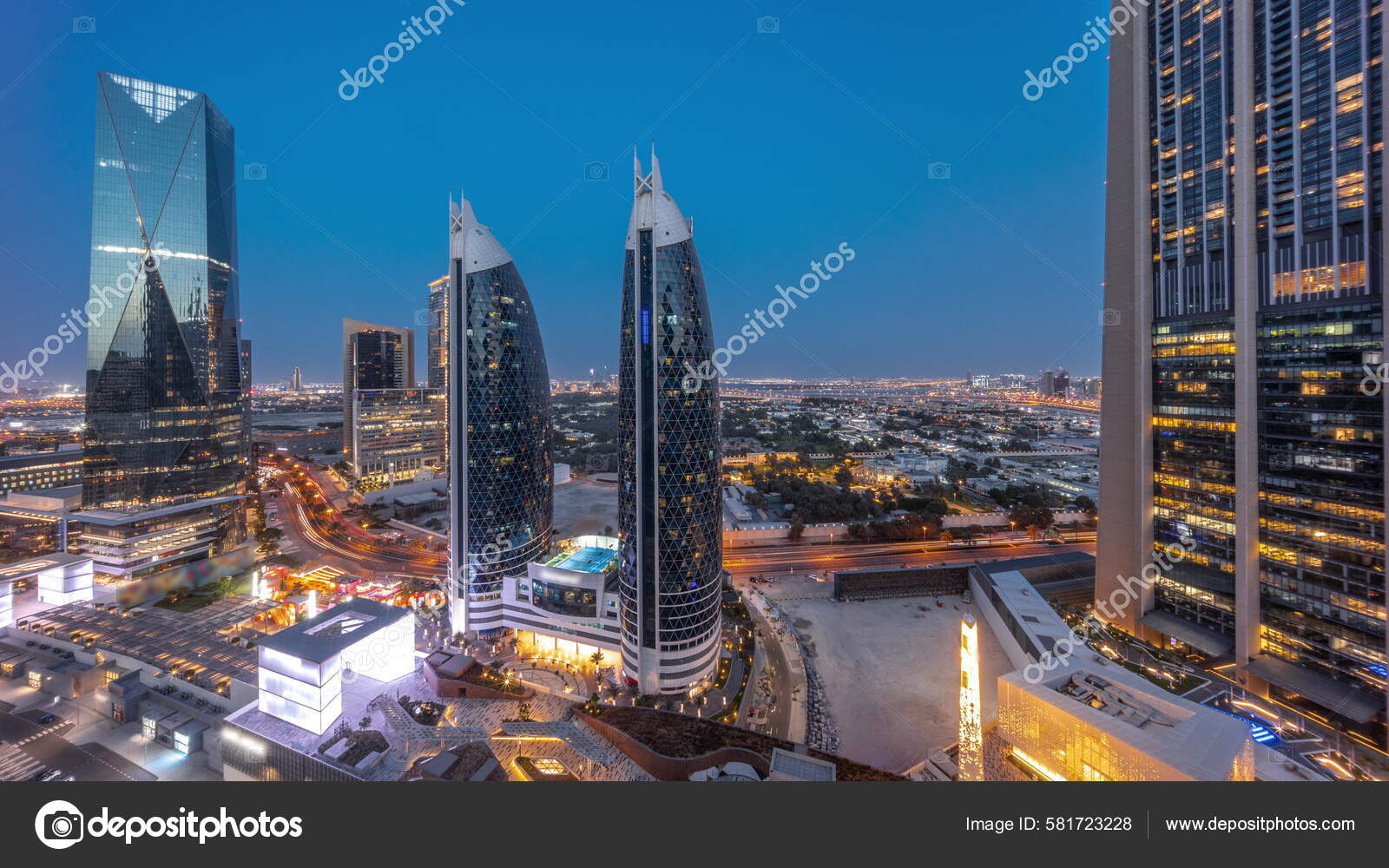 迪拜国际金融区的空中景观日落时分有许多摩天大楼从天到夜的过渡全景时间在有天台步行区的购物道附近的道路上