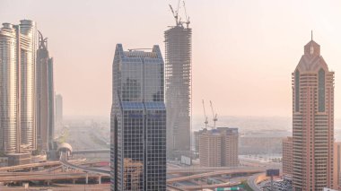 Dubai şehrinin silueti panoramik manzaralı metro ve araçlar şehrin en yoğun karayolu zaman aralığında ilerliyor. Gökdelenlerle çevrili bir kavşak