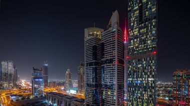 Dubai Uluslararası Finans Bölgesi 'nin birçok gökdelenli gece görüşü. Şeyh Zayed yolundaki kavşakta trafik vardı. Dubai, BAE.