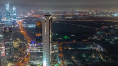 Dubai 'deki Dubai hava sahasındaki Dünya Ticaret Merkezi yakınlarındaki gökdelenler ve diğer binalar panoramik zaman çizelgesi. Otoyol kavşağında trafik ve yukarıdan otopark