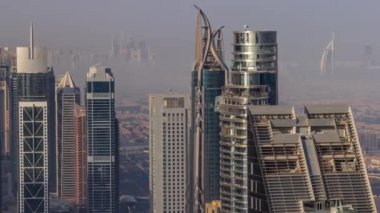 Şehir merkezinin ufuk çizgisi, modern mimari biçimli, zaman çizgisinin üstünde. Dubai iş hangarı kulelerinin hava görüntüsü. Arka planda Dubai marina gökdelenleri