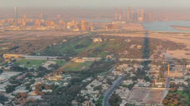 Zabeel bölgesindeki villalar Dubai, BAE 'de arka plan zaman aralığında gökdelenler. Gün batımında uzun gölgeli yollar ve aydınlık evleri olan caddelerde trafik